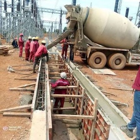 Crew pouring concrete into formwork on site